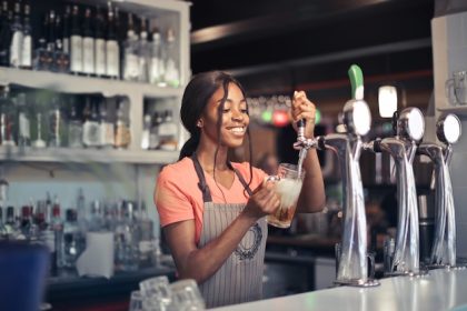 selective focus shot african american female bartender filling beer from bar pump 181624 12901
